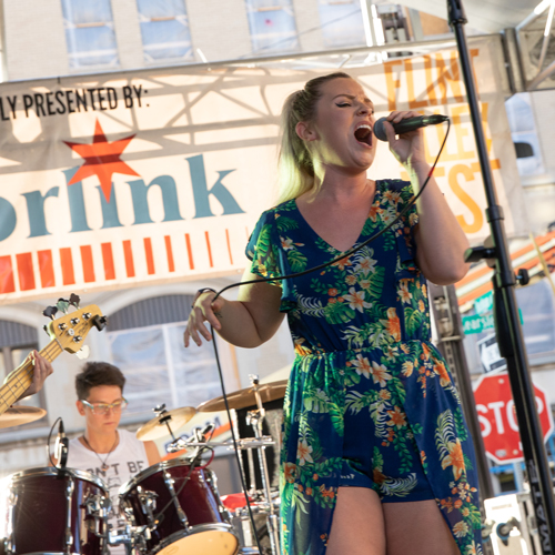 A female singer performs on stage during Alley Fest in downtown Flint.